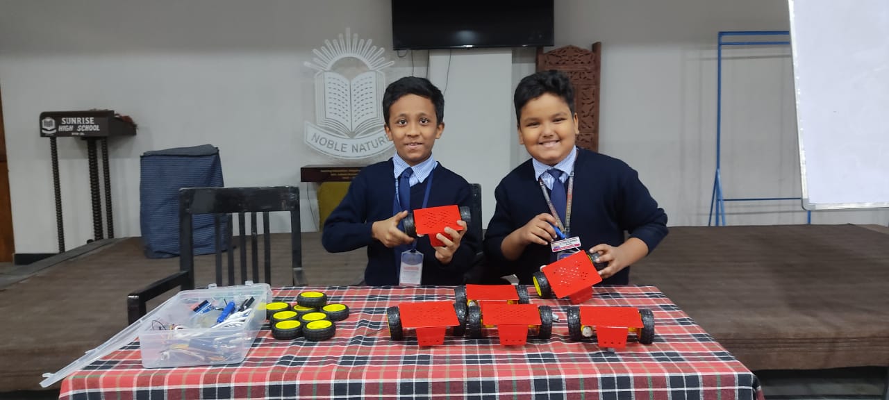 Students showcasing robotics projects in classroom